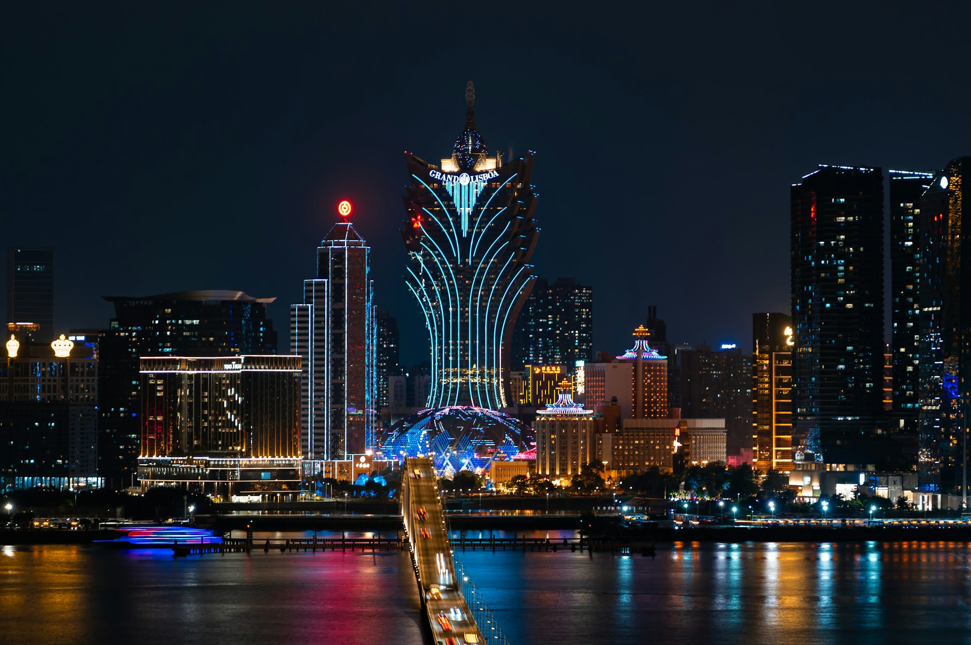 a city skyline at night with a bridge going across it